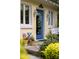Close-up of a blue front door flanked by windows, planters and vintage decor for inviting curb appeal at 34 Formosa Dr, Charleston, SC 29407