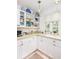 Bright kitchen with white cabinetry, decor and corner countertop window at 34 Formosa Dr, Charleston, SC 29407