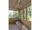 Screened-in porch with a ceiling fan and ample views of the surrounding lush greenery, ideal for relaxation at 34 Formosa Dr, Charleston, SC 29407