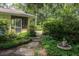 Charming home featuring a welcoming screened entrance and stone path, all surrounded by lush, landscaped side yard at 34 Formosa Dr, Charleston, SC 29407