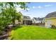 Charming yellow home featuring a spacious, manicured backyard with mature trees and lush green grass at 3413 Acorn Drop Ln, Johns Island, SC 29455