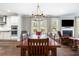 Open-concept dining room with large wooden table, decorative chandelier, and fireplace at 3413 Acorn Drop Ln, Johns Island, SC 29455