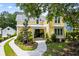 Lovely yellow two-story home featuring lush landscaping and a winding sidewalk at 3413 Acorn Drop Ln, Johns Island, SC 29455