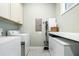 Functional laundry room with ample storage cabinets and a white front-load washer and dryer at 3413 Acorn Drop Ln, Johns Island, SC 29455