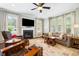 Bright living room with fireplace, large windows, ceiling fan, and comfortable seating at 3413 Acorn Drop Ln, Johns Island, SC 29455