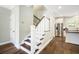View of a home's staircase and hardwood floors with stainless steel kitchen appliances in the background at 3413 Acorn Drop Ln, Johns Island, SC 29455