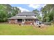 Expansive backyard showcasing a brick and white trim home with a patio, hot tub, and lush landscaping at 3601 Colonel Vanderhorst Cir, Mount Pleasant, SC 29466