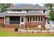 Brick home exterior highlighting a screened porch, patio access, and meticulously maintained garden beds at 3601 Colonel Vanderhorst Cir, Mount Pleasant, SC 29466