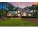 Stunning brick two-story home with manicured landscaping and a well-maintained lawn at dusk at 3601 Colonel Vanderhorst Cir, Mount Pleasant, SC 29466
