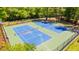 Aerial view of tennis courts surrounded by trees, featuring well-maintained blue playing surfaces at 4111 Rising Tide Dr, Summerville, SC 29485