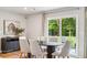 Sunlit dining room with outdoor view, featuring a modern sideboard and stylish curtains over a sliding glass door to patio at 4147 Rising Tide Dr, Summerville, SC 29485