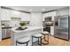 Stylish kitchen featuring white cabinets, stainless steel appliances, a kitchen island and hardwood floors at 4147 Rising Tide Dr, Summerville, SC 29485