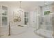 Bright bathroom features a standalone tub, glass enclosed shower, tiled floor, and modern chandelier at 4205 Cobble Trot Way, Johns Island, SC 29455