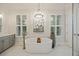 Bright bathroom featuring a standalone tub, a chandelier, marble tiled floor, and a gray vanity at 4205 Cobble Trot Way, Johns Island, SC 29455
