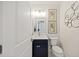 Stylish powder room featuring a marble countertop, navy blue vanity, and modern fixtures at 4205 Cobble Trot Way, Johns Island, SC 29455