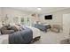 Bright bedroom features two twin beds, french doors, ceiling fan, and a wall-mounted television at 4205 Cobble Trot Way, Johns Island, SC 29455