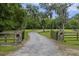 Gated gravel driveway with stone accents and lush greenery, providing privacy and curb appeal at 4205 Cobble Trot Way, Johns Island, SC 29455