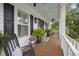 Inviting front porch with rocking chairs, wood flooring, white columns and festive décor at 4205 Cobble Trot Way, Johns Island, SC 29455