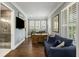 Bright home office with blue walls, hardwood floors, shutters, and a comfortable blue sofa at 4205 Cobble Trot Way, Johns Island, SC 29455