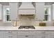 Close-up of a modern kitchen featuring a cooktop, light backsplash and white countertops at 4205 Cobble Trot Way, Johns Island, SC 29455