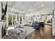 Open-concept living room flows into kitchen, featuring coffered ceilings and hardwood floors at 4205 Cobble Trot Way, Johns Island, SC 29455