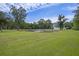 Wide-angle shot of a sprawling green lawn with a peaceful pond and fountain in the distance at 4205 Cobble Trot Way, Johns Island, SC 29455