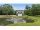 Scenic aerial view of a home with a lovely pond featuring a fountain and lush greenery at 4205 Cobble Trot Way, Johns Island, SC 29455
