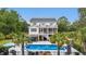 A backyard pool is surrounded by an outdoor bar, patio, palm trees and lush greenery at 4205 Cobble Trot Way, Johns Island, SC 29455