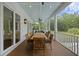 Large covered porch with a long wooden dining table and ceiling fan at 4205 Cobble Trot Way, Johns Island, SC 29455