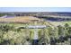 Aerial view of horse farm with paddocks, lake, and modern stable, set in a tranquil rural setting at 4233 Lady Banks Ln, Ravenel, SC 29470