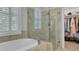 Bathroom featuring a soaking tub and glass-enclosed shower next to the walk-in closet at 4233 Lady Banks Ln, Ravenel, SC 29470