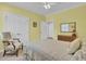 Bedroom with yellow walls, a ceiling fan, and large windows with shutter blinds at 4233 Lady Banks Ln, Ravenel, SC 29470