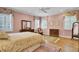 Cozy bedroom with wood floors, soft lighting, floral print curtains, matching furniture, and natural light at 4233 Lady Banks Ln, Ravenel, SC 29470