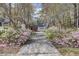 Long concrete driveway lined with beautiful pink and white flowers leading to the garage at 4233 Lady Banks Ln, Ravenel, SC 29470