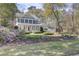 A beautiful two-story home surrounded by lush trees, flowers and manicured landscaping on a sunny day at 4233 Lady Banks Ln, Ravenel, SC 29470