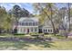 Charming two-story home with a covered porch, black shutters, and mature trees on a large lot at 4233 Lady Banks Ln, Ravenel, SC 29470