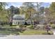 Beautiful home with manicured lawn and flowerbeds in a lush green setting, near a neighborhood street at 4233 Lady Banks Ln, Ravenel, SC 29470