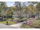 Charming two-story home with a covered porch surrounded by lush trees and mature landscaping at 4233 Lady Banks Ln, Ravenel, SC 29470