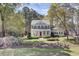 Inviting two-story home with a covered porch, manicured lawn, and mature trees in a lush setting at 4233 Lady Banks Ln, Ravenel, SC 29470