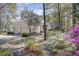 Exterior elevation of the home featuring a three-car garage and a yard with azaleas at 4233 Lady Banks Ln, Ravenel, SC 29470