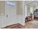 Entryway with hardwood flooring, white trim, and a view into an adjacent room with a bookcase at 4233 Lady Banks Ln, Ravenel, SC 29470