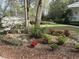 Charming front yard features colorful landscaping, mulch beds, and a glimpse of the home's exterior at 4233 Lady Banks Ln, Ravenel, SC 29470