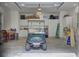 A golf cart sits inside a clean and well-organized garage space with white cabinets at 4233 Lady Banks Ln, Ravenel, SC 29470