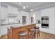 Bright kitchen boasts white cabinets, stainless steel appliances, granite counters and island seating at 4233 Lady Banks Ln, Ravenel, SC 29470