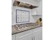 A kitchen cooktop has granite countertops, white cabinets, and tile backsplash at 4233 Lady Banks Ln, Ravenel, SC 29470