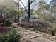 Stone pathway leading to a home with beautiful landscaping, colorful plants and lush greenery at 4233 Lady Banks Ln, Ravenel, SC 29470