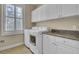 This laundry room features granite countertops, white cabinets, washer, dryer, and natural light at 4233 Lady Banks Ln, Ravenel, SC 29470