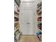 Pantry with white bi-fold doors, featuring ample shelving and tiled floors, offering organized food and supply storage at 4233 Lady Banks Ln, Ravenel, SC 29470
