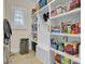 Spacious pantry with ample shelving, beverage fridge, natural light and organized storage for food and household essentials at 4233 Lady Banks Ln, Ravenel, SC 29470