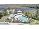 Aerial view of a pool with gray decking, palm trees, lounge chairs, and a pool house overlooking the waterway at 4233 Lady Banks Ln, Ravenel, SC 29470